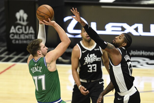 Dallas Mavericks guard Luka Doncic, left, shoots over Los Angeles Clippers guard Paul George during the first half of an NBA basketball game in Los Angeles, Sunday, Dec. 27, 2020. (AP Photo/Kyusung Gong)