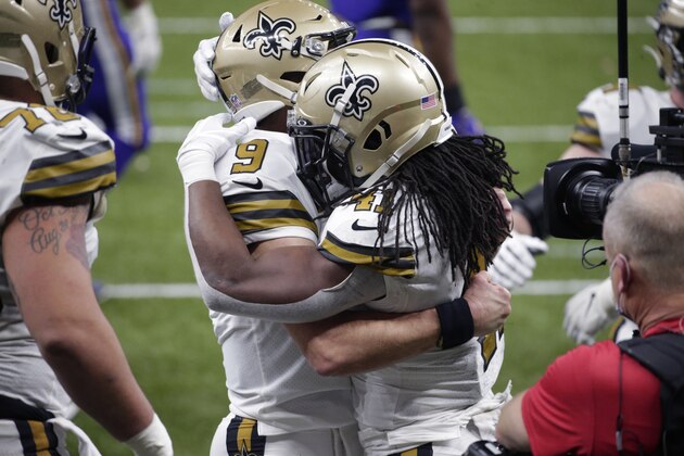 New Orleans Saints running back Alvin Kamara (41) hugs quarterback Drew Brees (9) after scoring his sixth touchdown of the game, tying the NFL record for most rushing touchdowns in a game, in the second half of an NFL football game against the Minnesota Vikings in New Orleans, Friday, Dec. 25, 2020. Drew Brees also set an NFL record as the first player to ever reach 80,000 yards passing. (AP Photo/Butch Dill)
