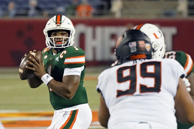 Miami quarterback D'Eriq King (1) looks for a receiver as Oklahoma State defensive tackle Sione Asi (99) rushes during the first half of the Cheez-it Bowl NCAA college football game, Tuesday, Dec. 29, 2020, in Orlando, Fla. (AP Photo/John Raoux)