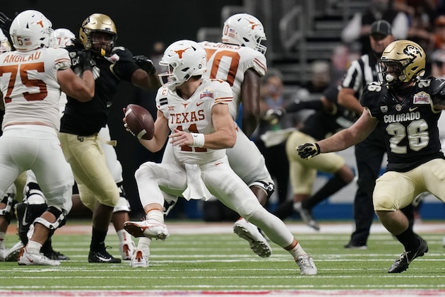 Texas quarterback Sam Ehlinger (11) sidesteps Colorado linebacker Carson Wells (26) during the first half of the Alamo Bowl NCAA college football game Tuesday, Dec. 29, 2020, in San Antonio. (AP Photo/Eric Gay)