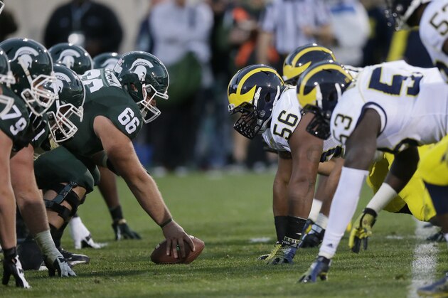 Michigan State and Michigan face off at the scrimmage line during the second half of an NCAA college football game in East Lansing, Mich., Saturday, Oct. 25, 2014. (AP Photo/Carlos Osorio)