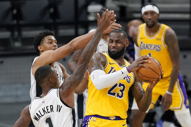 Los Angeles Lakers forward LeBron James (23) is pressured by San Antonio Spurs guard Lonnie Walker IV (1) and guard Keldon Johnson during the first half of an NBA basketball game in San Antonio, Wednesday, Dec. 30, 2020. (AP Photo/Eric Gay) Los Angeles Lakers forward LeBron James (23) is pressured by San Antonio Spurs guard Lonnie Walker IV (1) and guard Keldon Johnson during the first half of an NBA basketball game in San Antonio, Wednesday, Dec. 30, 2020. (AP Photo/Eric Gay)