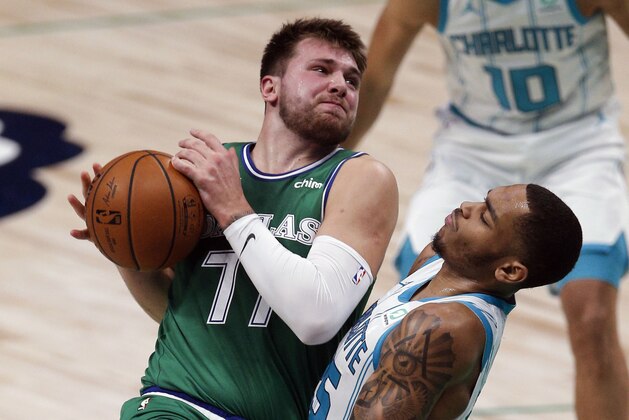 Dallas Mavericks guard Luka Doncic (77) battles Charlotte Hornets forward P.J. Washington (25) for space during the first half of an NBA basketball game, Wednesday, Dec. 30, 2020, in Dallas. (AP Photo/Brandon Wade)