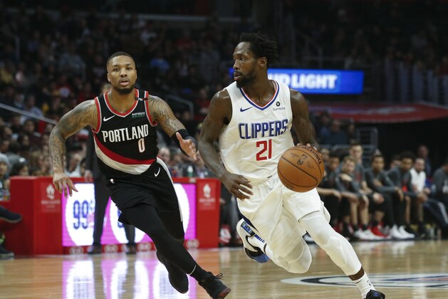 Los Angeles Clippers' Patrick Beverley (21) drives against Portland Trail Blazers' Damian Lillard (0) during an NBA basketball game between Los Angeles Clippers and Portland Trail Blazers, Tuesday, March 12, 2019, in Los Angeles. (AP Photo/Ringo H.W. Chiu)
