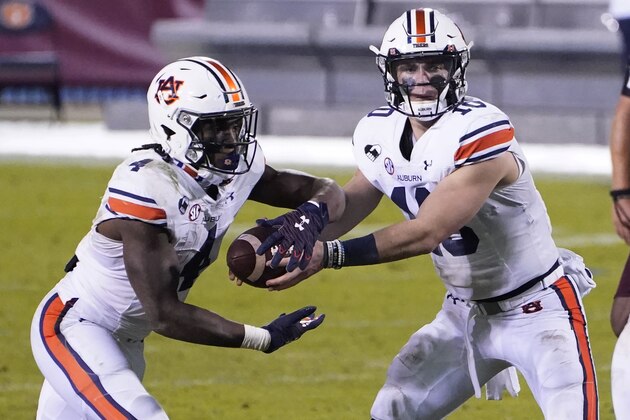 Auburn quarterback Bo Nix (10) hands off to running back Tank Bigsby (4) during the second half of the team's NCAA college football game against Mississippi State, Saturday, Dec. 12, 2020, in Starkville, Miss.  (AP Photo/Rogelio V. Solis)