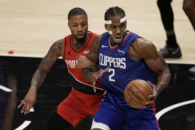 Portland Trail Blazers' Damian Lillard, left, grabs the arm of Los Angeles Clippers' Kawhi Leonard during the first half of an NBA basketball game Wednesday, Dec. 30, 2020, in Los Angeles. (AP Photo/Jae C. Hong)
