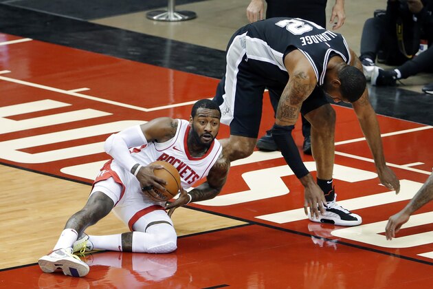 Houston Rockets guard John Wall (1) comes up with a loose ball in front of San Antonio Spurs forward LaMarcus Aldridge (12) during the first half of an NBA basketball game Tuesday, Dec. 15, 2020, in Houston. (AP Photo/Michael Wyke)