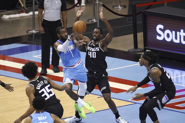 Houston Rockets guard John Wall passes the ball around Sacramento Kings' Harrison Barnes during the first half of an NBA basketball game Thursday, Dec. 31, 2020, in Houston. (AP Photo/Richard Carson)