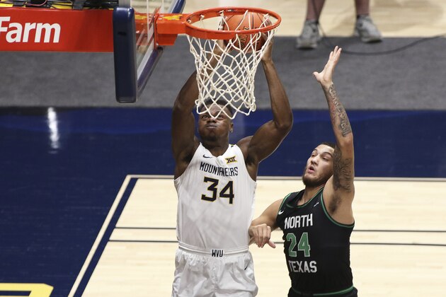 West Virginia forward Oscar Tshiebwe (34) shoots while defended by North Texas forward Zachary Simmons (24) during the first half of an NCAA college basketball game Friday, Dec. 11, 2020, in Morgantown, W.Va. (AP Photo/Kathleen Batten)