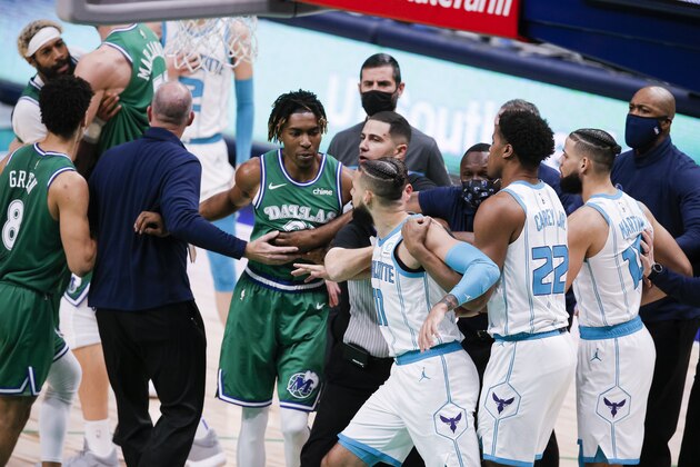Coaches and officials separate Dallas Mavericks and Charlotte Hornets players during a scuffle in the second half of an NBA basketball game, Wednesday, Dec. 30, 2020, in Dallas. Charlotte Hornets forward Cody Martin (11) and Dallas Mavericks forward James Johnson (16) were both ejected for taunting. Charlotte won 118-99. (AP Photo/Brandon Wade)