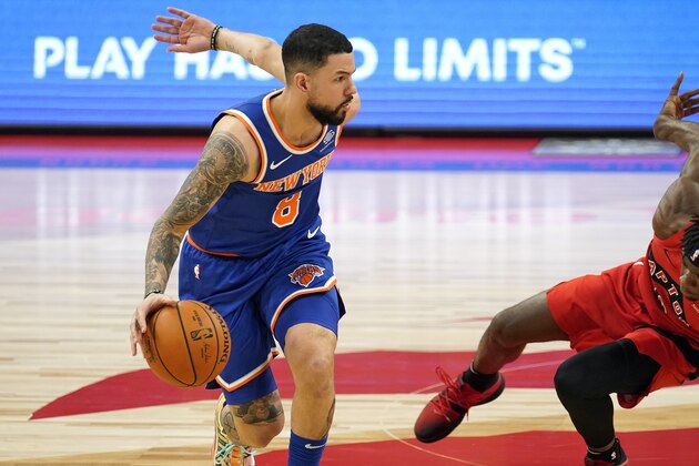 Toronto Raptors guard Terence Davis (0) falls down as New York Knicks guard Austin Rivers (8) drives up the court during the first half of an NBA basketball game Thursday, Dec. 31, 2020, in Tampa, Fla. (AP Photo/Chris O'Meara)