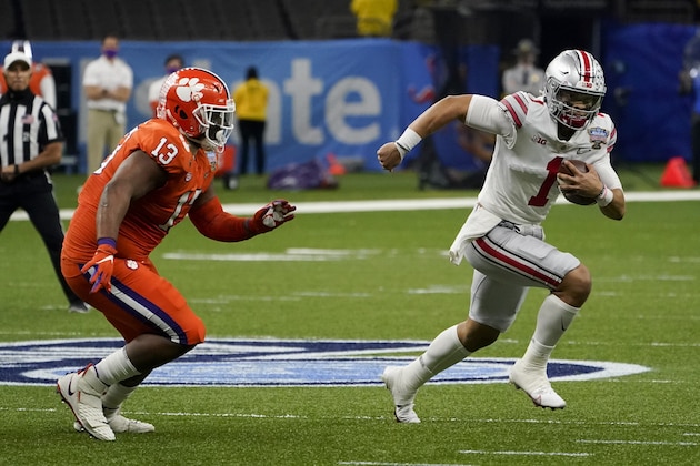 Ohio State quarterback Justin Fields runs past Clemson defensive tackle Tyler Davis during the first half of the Sugar Bowl NCAA college football game Friday, Jan. 1, 2021, in New Orleans. (AP Photo/John Bazemore)