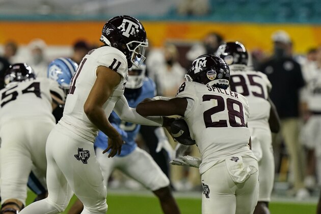 Texas A&M quarterback Kellen Mond (11) hands the football to running back Isaiah Spiller (28), during the first half of the Orange Bowl NCAA college football game against North Carolina, Saturday, Jan. 2, 2021, in Miami Gardens, Fla. (AP Photo/Marta Lavandier)