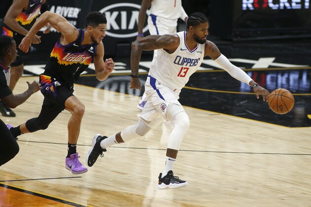 Los Angeles Clippers forward Paul George (13) chases a loose ball after knocking it away from Phoenix Suns guard Devin Booker (1) during the first half of an NBA basketball game Sunday, Jan. 3, 2021, in Phoenix. (AP Photo/Ralph Freso)