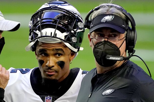 Philadelphia Eagles quarterback Jalen Hurts, center, talks with head coach Doug Pederson during the second half of an NFL football game against the Arizona Cardinals, Sunday, Dec. 20, 2020, in Glendale, Ariz. (AP Photo/Rick Scuteri)