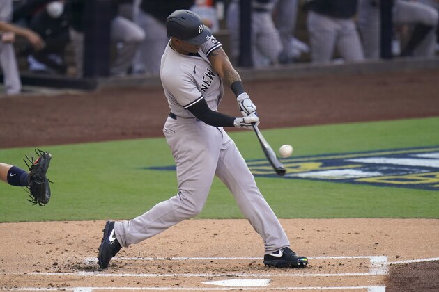 New York Yankees center fielder Aaron Hicks connects for a sacrifice fly to drive in a run against the Tampa Bay Rays during the first inning in Game one of a baseball American League Division Series Monday, Oct. 5, 2020, in San Diego. DJ LeMahieu scored on the play. (AP Photo/Jae C. Hong)