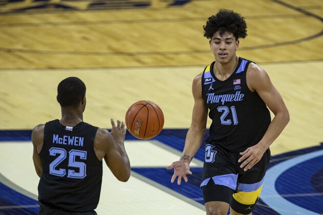 Marquette guard D.J. Carton (21) passes the ball to Marquette guard Koby McEwen (25) in the game against Creighton during an NCAA basketball game on Monday, Dec. 14, 2020, in Omaha, Neb. (AP Photo/John Peterson)