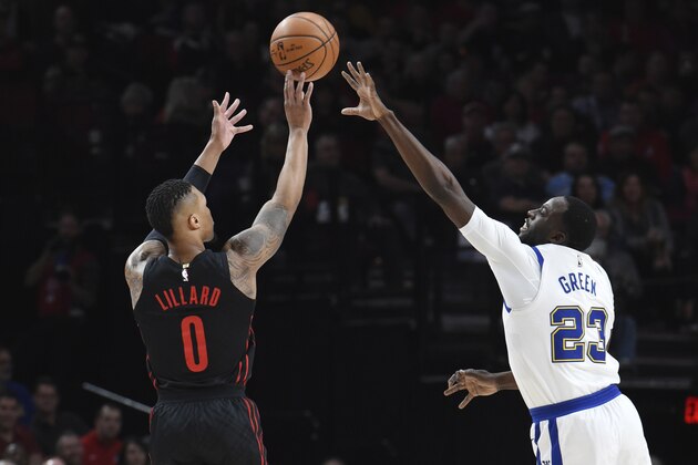 Portland Trail Blazers guard Damian Lillard hits a 3-point shot over Golden State Warriors forward Draymond Green during the first half of an NBA basketball game in Portland, Ore., Friday, March 9, 2018. (AP Photo/Steve Dykes)
