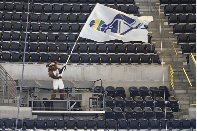 Utah Jazz Bear waves a flag before an NBA preseason basketball game against the Phoenix Suns Saturday, Dec. 12, 2020, in Salt Lake City. (AP Photo/Rick Bowmer)