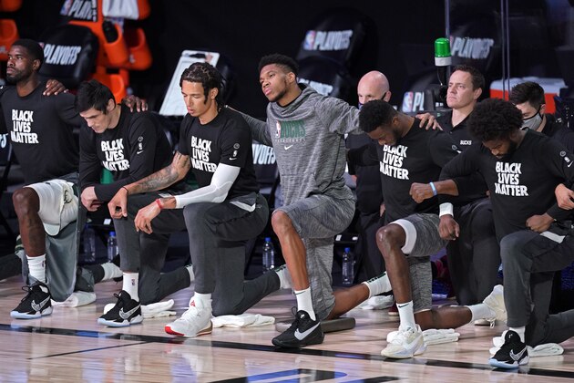Milwaukee Bucks' Giannis Antetokounmpo, center, kneels with teammates during the national anthem before Game 5 of an NBA basketball Eastern Conference semifinal against the Miami Heat Tuesday, Sept. 8, 2020 in Lake Buena Vista, Fla. (AP Photo/Mark J. Terrill)