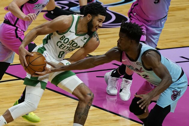 Miami Heat forward Jimmy Butler (22) defends Boston Celtics forward Jayson Tatum (0) during the first half of an NBA basketball game, Wednesday, Jan. 6, 2021, in Miami. (AP Photo/Marta Lavandier)