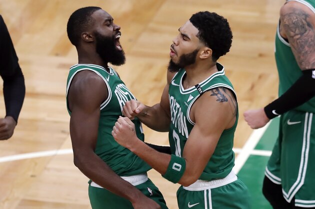 Boston Celtics' Jayson Tatum (0) celebrates with Jaylen Brown (7) after making the go-ahead basket with less than a second on the clock during the second half of an NBA basketball game against the Milwaukee Bucks, Wednesday, Dec. 23, 2020, in Boston. (AP Photo/Michael Dwyer)