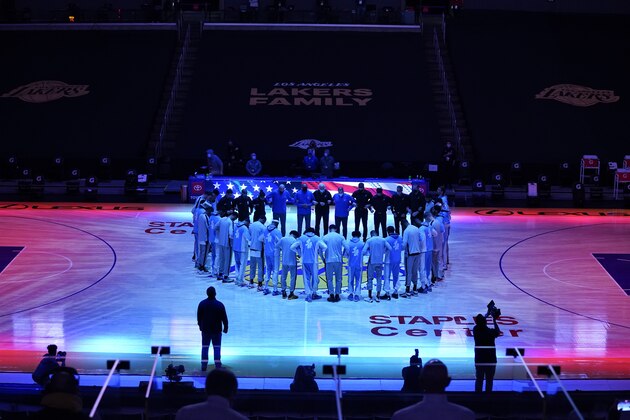 The San Antonio Spurs and the Los Angeles Lakers stand in a circle as the national anthem played before an NBA basketball game Thursday, Jan. 7, 2021, in Los Angeles. (AP Photo/Ashley Landis)