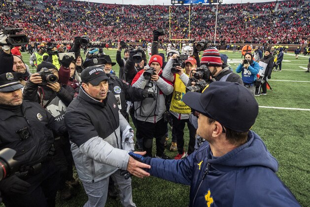Ohio State head coach Ryan Day, front left, shakes hands with Michigan head coach Jim Harbaugh, front right, after an NCAA college football game in Ann Arbor, Mich., Saturday, Nov. 30, 2019. Ohio State won 56-27. (AP Photo/Tony Ding)
