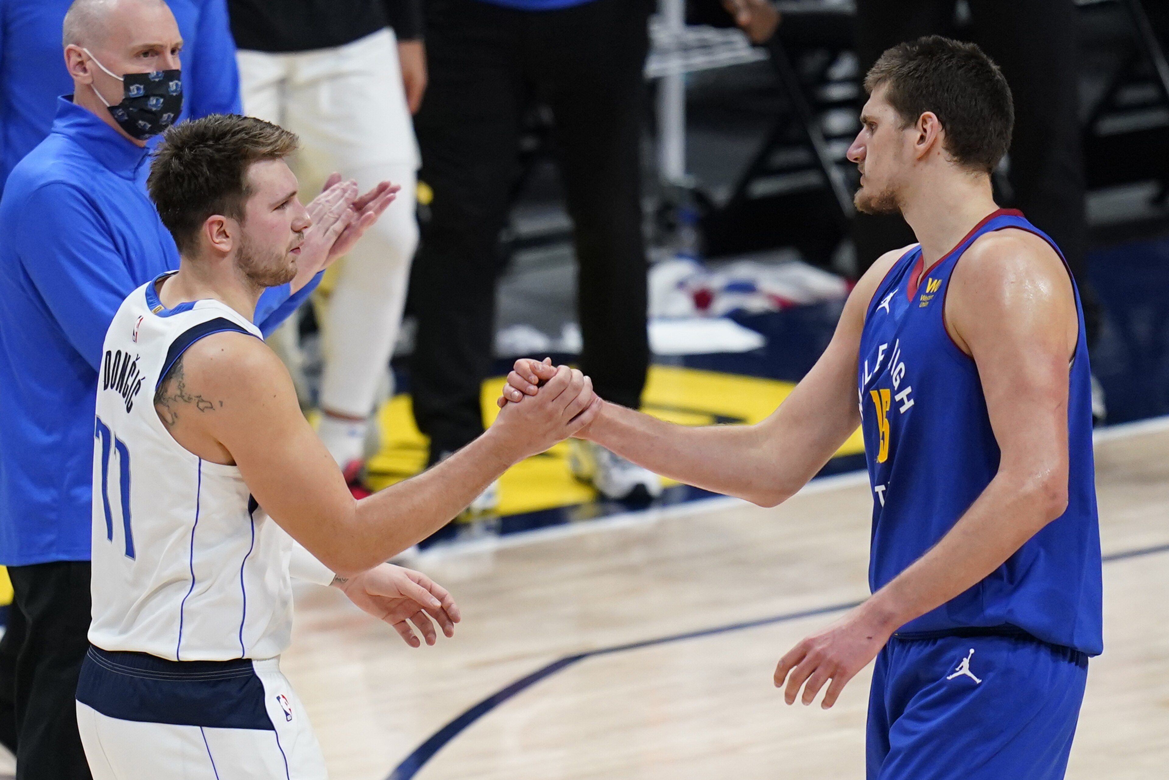 Dallas Mavericks guard Luka Doncic (77) and Denver Nuggets center Nikola Jokic (15) shake hands after the Maverick's 124-117 overtime win in an NBA basketball game Thursday, Jan. 7, 2021, in Denver. (AP Photo/Jack Dempsey)