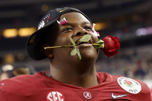 Alabama offensive lineman Javion Cohen holds a rose between his teeth after their 31-14 win against Notre Dame in the Rose Bowl NCAA college football game in Arlington, Texas, Friday, Jan. 1, 2021. (AP Photo/Michael Ainsworth)