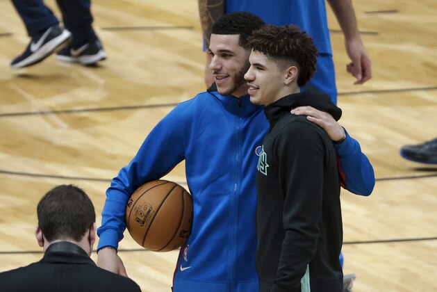 New Orleans Pelicans guard Lonzo Ball, center left, and Charlotte Hornets guard LaMelo Ball pose for a photo on the court prior to an NBA basketball game in New Orleans, Friday, Jan. 8, 2021. (AP Photo/Derick Hingle)