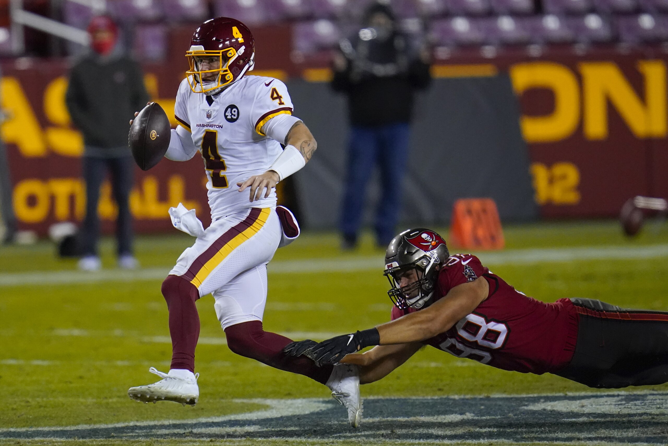 Washington Football Team quarterback Taylor Heinicke (4) his chased down by Tampa Bay Buccaneers outside linebacker Anthony Nelson (98) during the second half of an NFL wild-card playoff football game, Saturday, Jan. 9, 2021, in Landover, Md. (AP Photo/Julio Cortez) Washington Football Team quarterback Taylor Heinicke (4) his chased down by Tampa Bay Buccaneers outside linebacker Anthony Nelson (98) during the second half of an NFL wild-card playoff football game, Saturday, Jan. 9, 2021, in Landover, Md. (AP Photo/Julio Cortez)