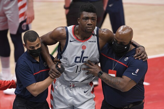 Washington Wizards center Thomas Bryant (13) is helped off the court after he was injured during the first half of an NBA basketball game against the Miami Heat, Saturday, Jan. 9, 2021, in Washington. (AP Photo/Nick Wass)