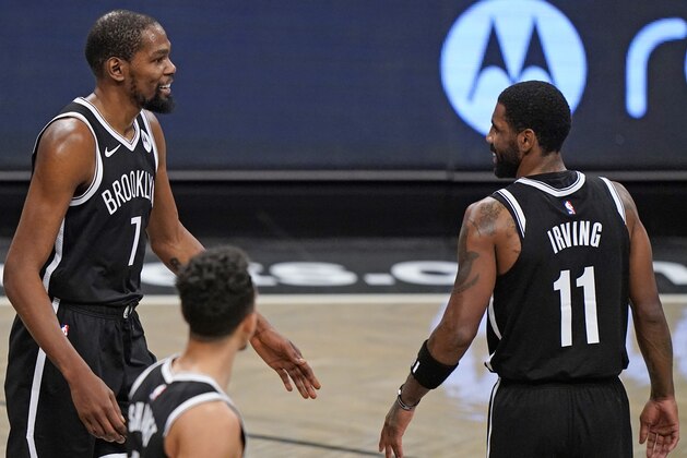 Brooklyn Nets forward Kevin Durant (7) approaches Nets guard Kyrie Irving (11) during the first half of a preseason NBA basketball game, Sunday, Dec. 13, 2020, in New York. (AP Photo/Kathy Willens)
