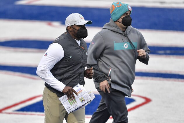 Miami Dolphins head coach Brian Flores, left, takes the field before the first half of an NFL football game against the Buffalo Bills, Sunday, Jan. 3, 2021, in Orchard Park, N.Y. (AP Photo/Adrian Kraus)