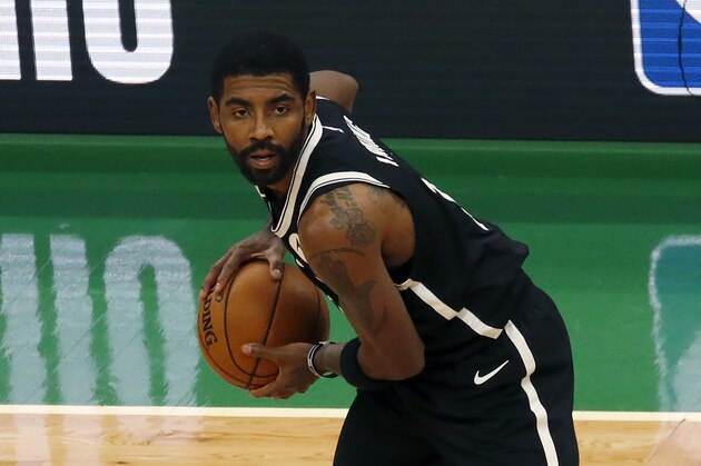 Brooklyn Nets guard Kyrie Irving (11) looks to pass during the first half of an NBA preseason basketball game against the Boston Celtics, Friday, Dec. 18, 2020, in Boston. (AP Photo/Mary Schwalm)