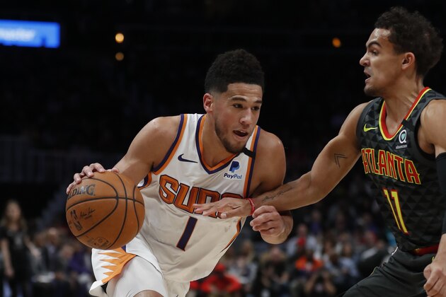 Phoenix Suns guard Devin Booker (1) drives against Atlanta Hawks guard Trae Young (11) in the first half of an NBA basketball game Tuesday, Jan. 14, 2020, in Atlanta. (AP Photo/John Bazemore)