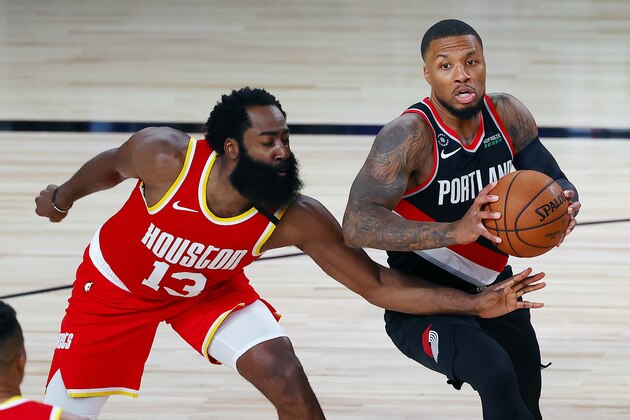 Portland Trail Blazers' Damian Lillard (0) handles the ball against Houston Rockets' James Harden (13) during the second half of an NBA basketball game Tuesday, Aug. 4, 2020, in Lake Buena Vista, Fla. (Kevin C. Cox/Pool Photo via AP)