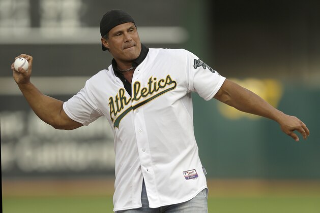Former Oakland Athletics player Jose Canseco throws out the ceremonial first pitch prior to a baseball game against the Boston Red Sox, Saturday, Sept. 3, 2016, in Oakland, Calif. (AP Photo/Ben Margot)