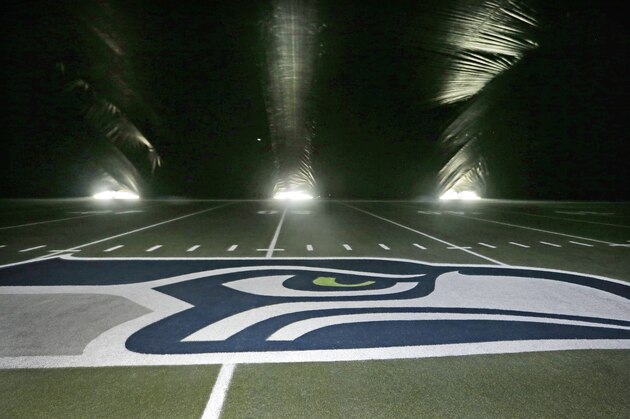 A newly-painted Seattle Seahawks' logo for the divisional playoff game sits in the center of the field in the dark under a giant tarp covering the artificial playing surface at the teams' field, CenturyLink Field, Thursday, Jan. 8, 2015, in preparation for Saturday's game against the Carolina Panthers, in Seattle. The tarp, resembling a massive pillow as fans blowing from underneath lift it up to several stories high, is protecting and allowing newly-painted logos and field markings underneath to dry. (AP Photo/Elaine Thompson)