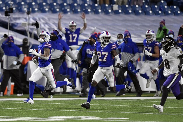 Buffalo Bills cornerback Taron Johnson, left, runs away from Baltimore Ravens quarterback Lamar Jackson (8) after intercepting his pass for a touchdown during the second half of an NFL divisional round football game Saturday, Jan. 16, 2021, in Orchard Park, N.Y. (AP Photo/Adrian Kraus)