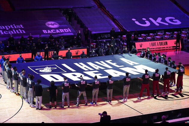Miami Heat and Detroit Pistons players hold a