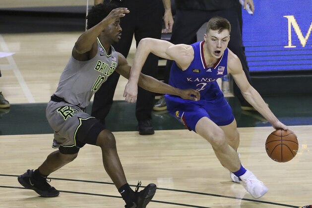 Kansas guard Christian Braun, right, drives against Baylor guard Adam Flagler, left, in the first half of an NCAA college basketball game, Monday, Jan. 18, 2021, in Waco, Texas. (AP Photo/Jerry Larson)