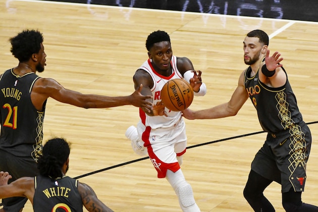 Houston Rockets guard Victor Oladipo, center, passes between Chicago Bulls forward Thaddeus Young, left, and guard Zach LaVine, right, during the second half of an NBA basketball game Monday, Jan. 18, 2021, in Chicago. (AP Photo/Matt Marton)