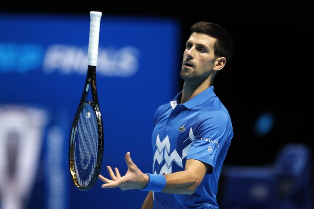 Novak Djokovic of Serbia juggles with his racket during the semifinal match against Dominic Thiem of Austria at the ATP World Finals tennis tournament at the O2 arena in London, Saturday, Nov. 21, 2020. (AP Photo/Frank Augstein)