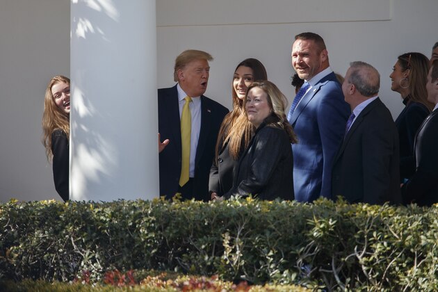 President Donald Trump talks with people on the colonnade, including Chicago Bears and Hall of Fame linebacker Brian Urlacher, fifth from left, after arriving at the White House in Washington, Monday, March, 9, 2020. The president is returning from Florida (AP Photo/Carolyn Kaster)