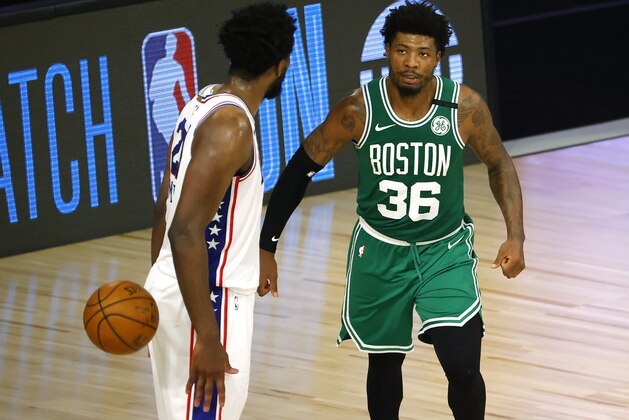 Marcus Smart of the Boston Celtics, right, stares down Joel Embiid of the Philadelphia 76ers after drawing the foul during the third quarter of Game 2 of an NBA basketball first-round playoff series, Wednesday, Aug. 19, 2020, in Lake Buena Vista, Fla. (Kevin C. Cox/Pool Photo via AP)