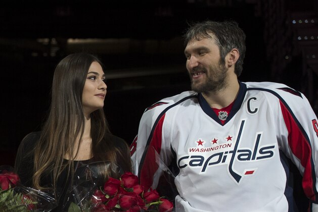 Washington Capitals' Alex Ovechkin, right, smiles at his wife Nastya Shubskaya during a ceremony for recording his 1,000th NHL point, before an NHL hockey game against the Los Angeles Kings, Sunday, Feb. 5, 2017, in Washington. (AP Photo/Molly Riley)