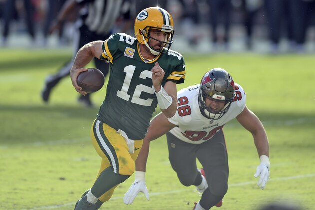 Green Bay Packers quarterback Aaron Rodgers (12) outruns Tampa Bay Buccaneers linebacker Anthony Nelson (98) during the first half of an NFL football game Sunday, Oct. 18, 2020, in Tampa, Fla. (AP Photo/Jason Behnken)