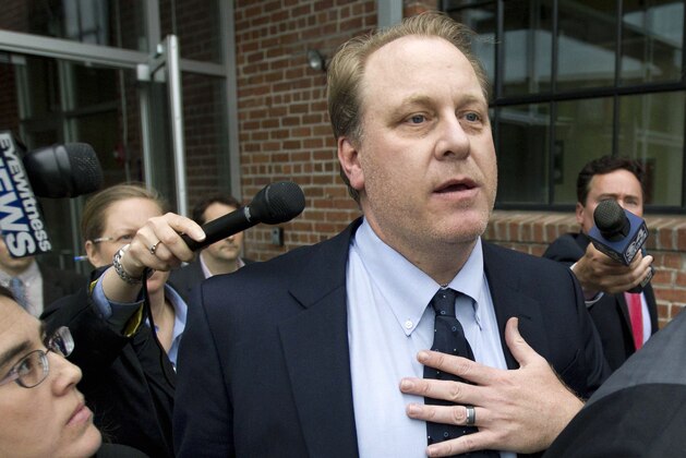FILE - In this Wednesday, May 16, 2012, file photo, former Boston Red Sox pitcher Curt Schilling, center, is followed by members of the media as he departs the Rhode Island Economic Development Corporation headquarters, in Providence, R.I. Wells Fargo Securities has agreed to pay an $800,000 civil penalty to settle a U.S. Securities and Exchange Commission lawsuit over Rhode Island's failed $75 million deal with Schilling's 38 Studios video game company. Wells Fargo and the SEC announced the proposed settlement in filings with the U.S. District Court in Providence on Monday, March 18,2019. A federal judge must approve it. (AP Photo/Steven Senne, File)